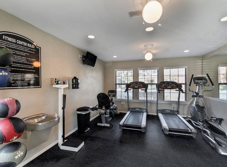 Fitness center with treadmills and three windows with blinds